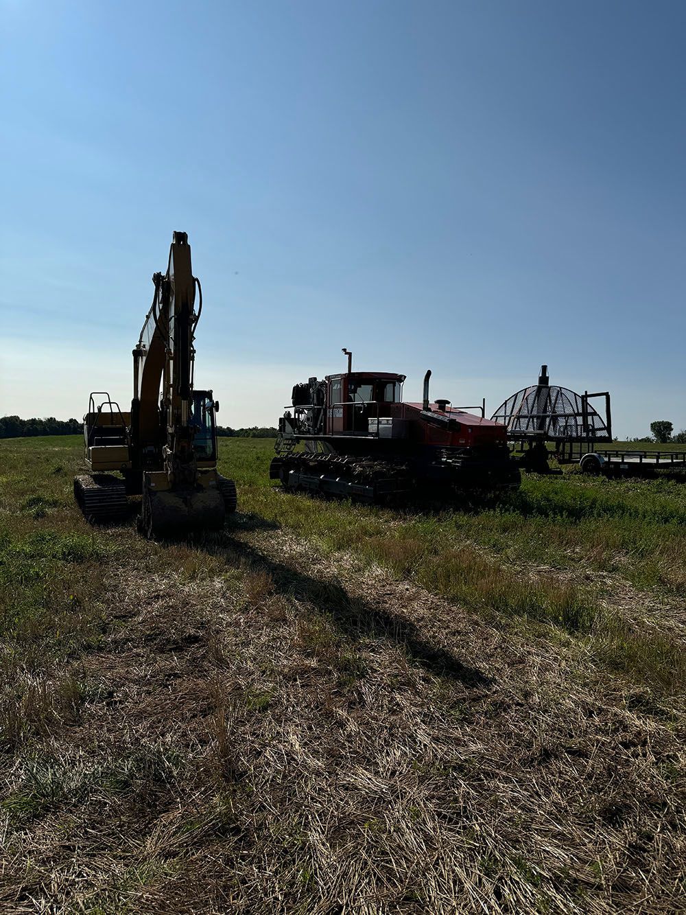 A couple of tractors are parked in a field.
