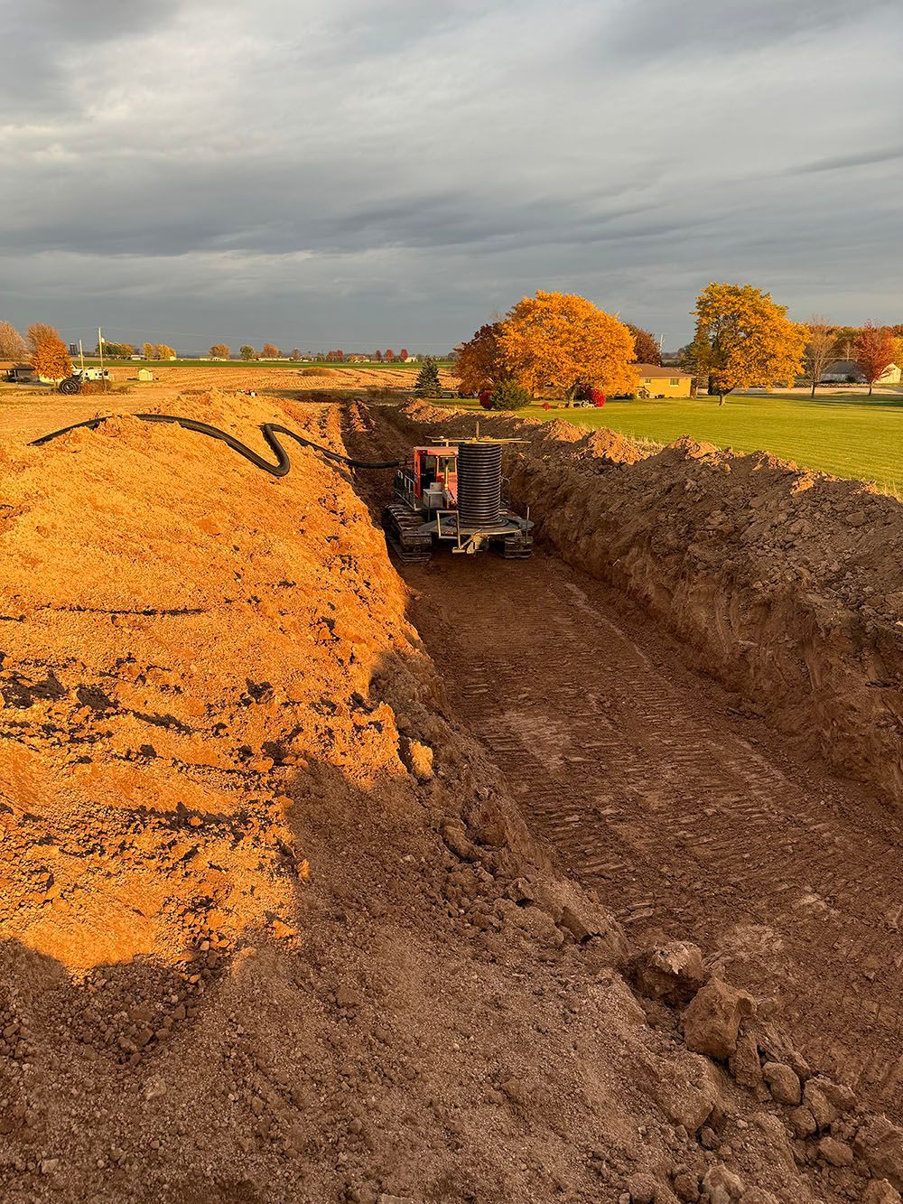 A tractor is digging a hole in the dirt in a field.