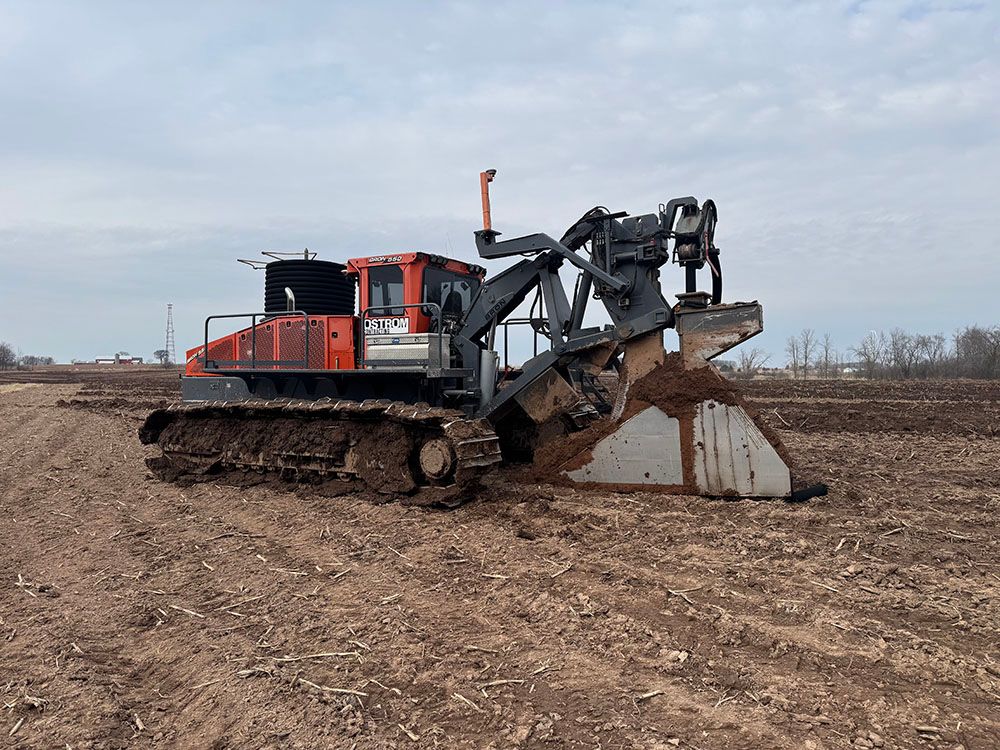 A bulldozer is sitting in the middle of a dirt field.