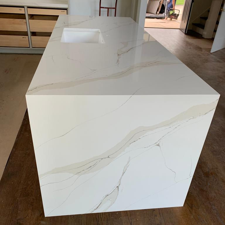 A white counter top with a sink in a kitchen