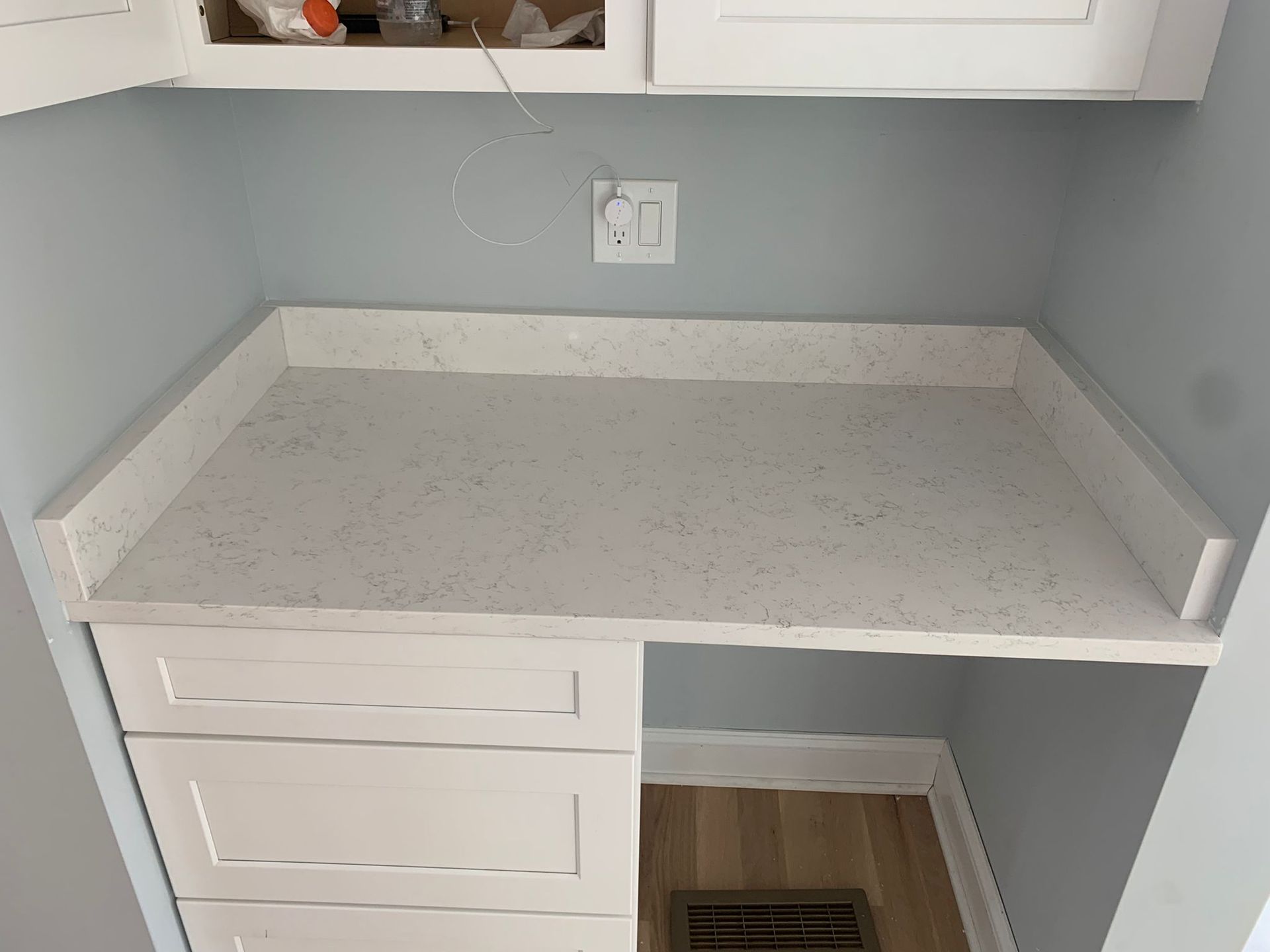 A kitchen with white cabinets and a white counter top