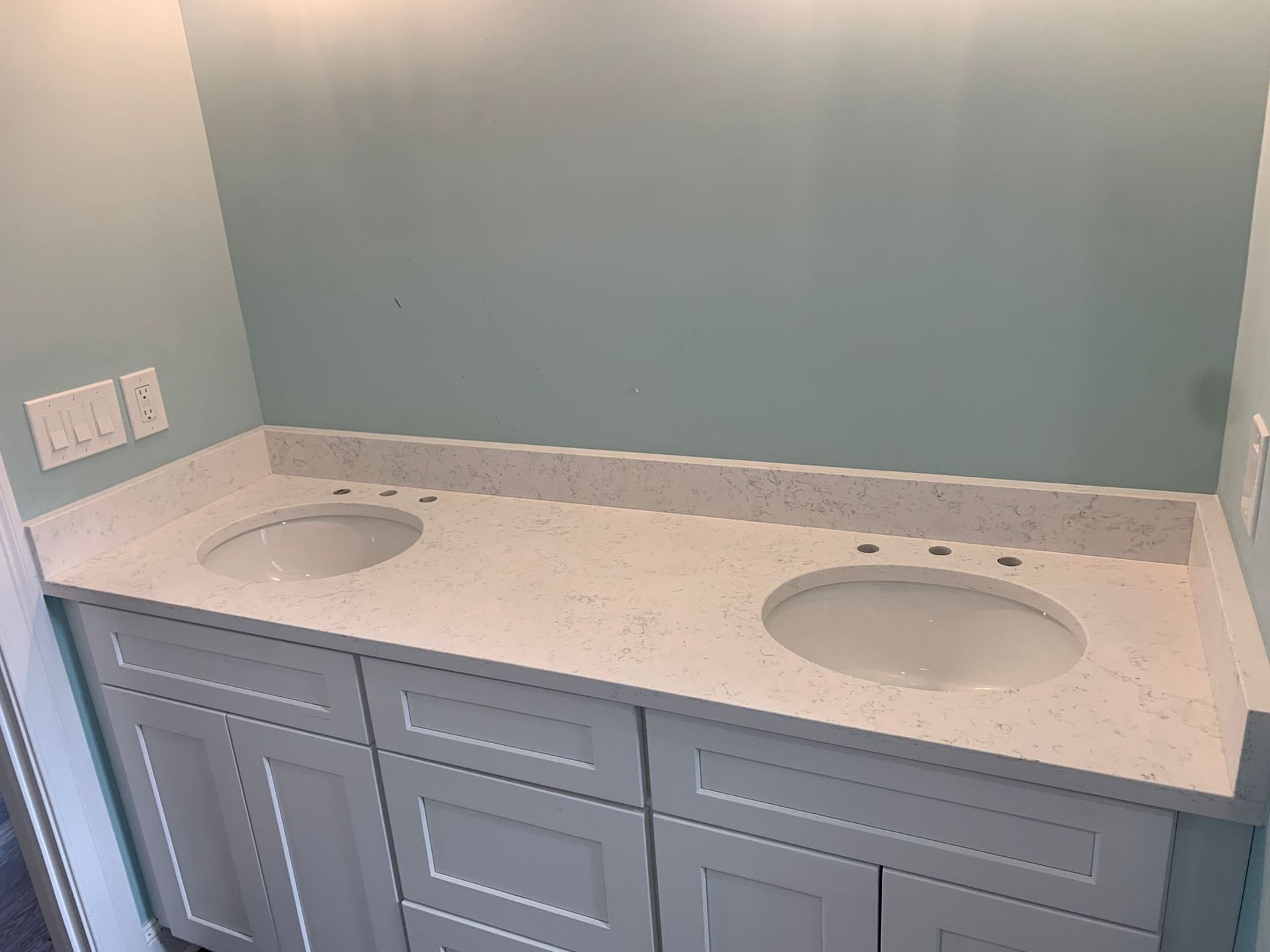 A bathroom with two sinks and blue walls.