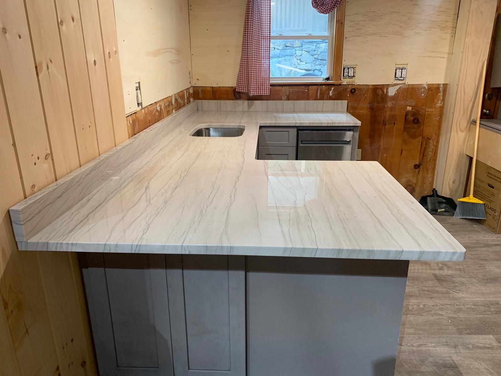 A kitchen with a granite counter top and a sink.