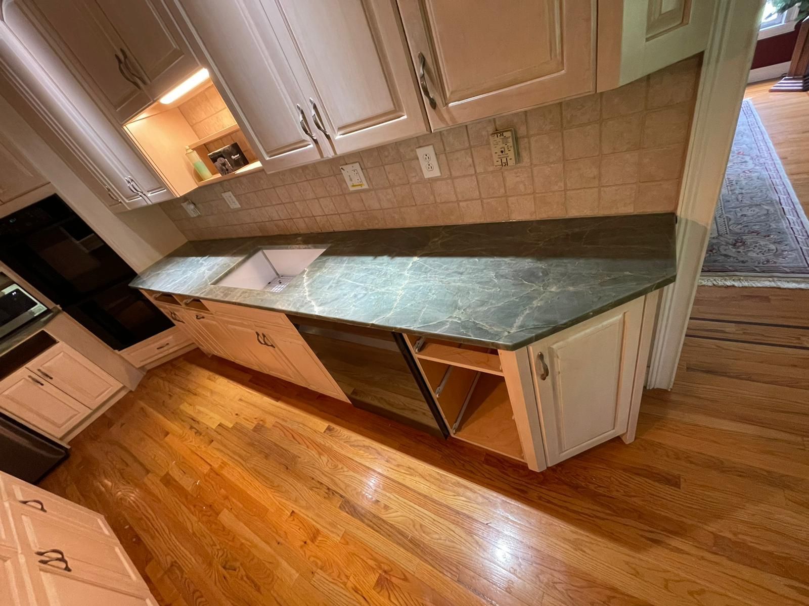 A kitchen with white cabinets and a granite counter top.