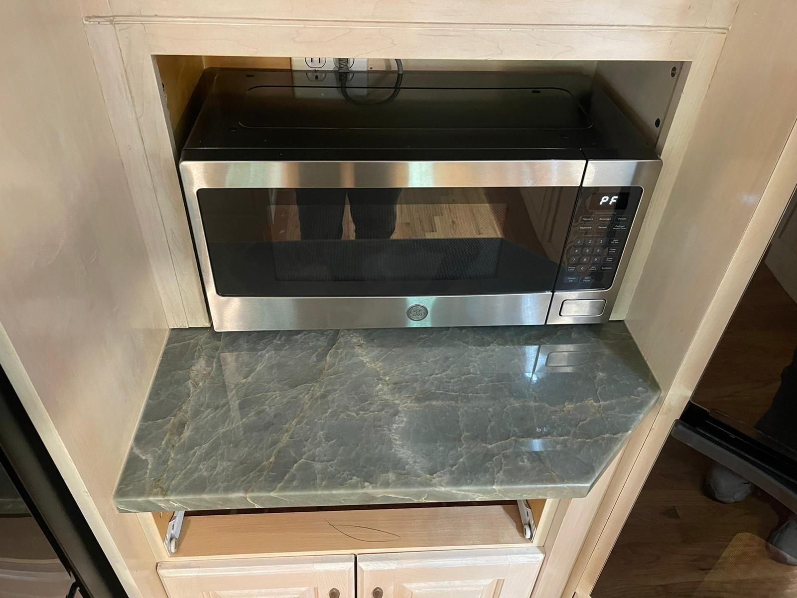 A microwave oven is sitting on top of a counter in a kitchen.