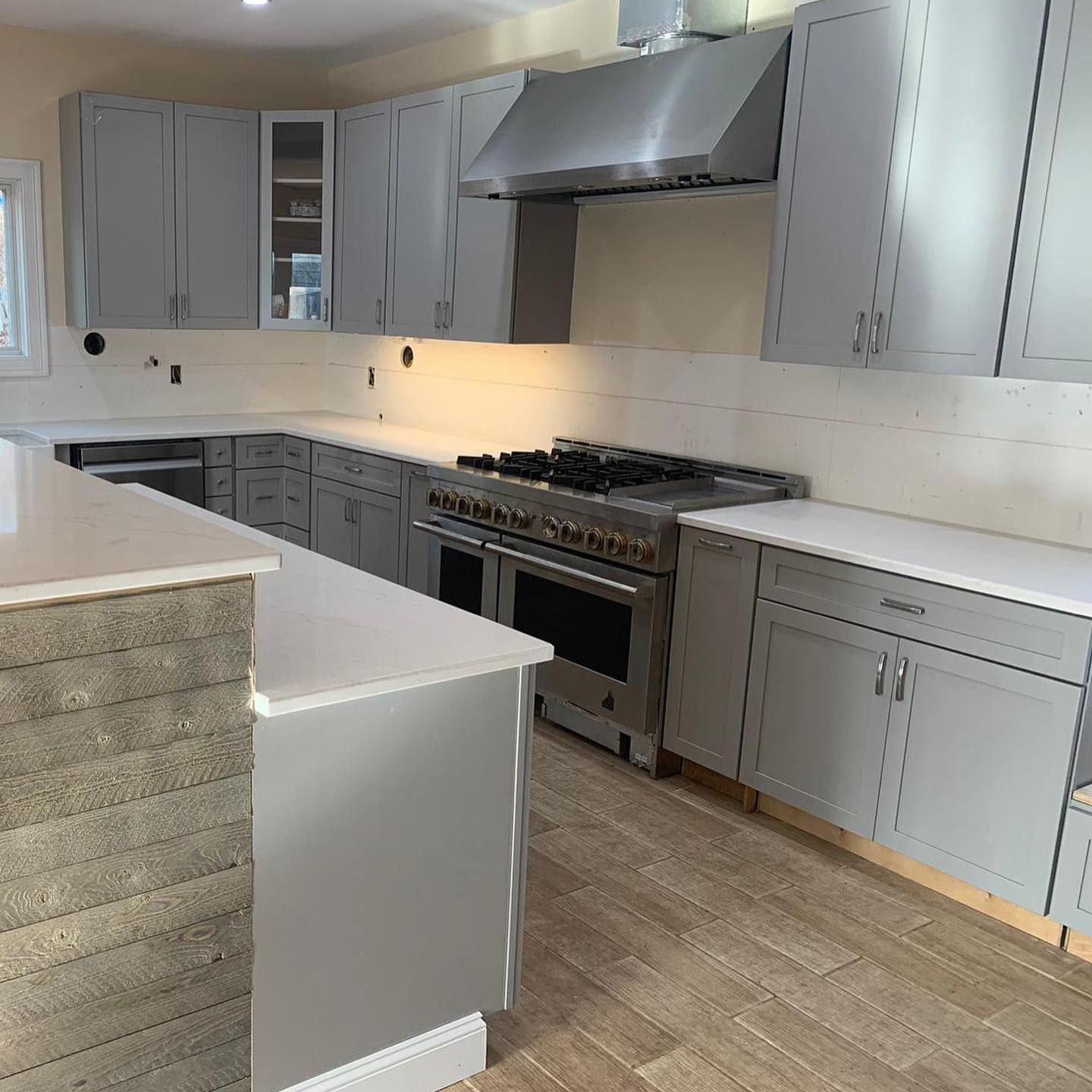 A kitchen with stainless steel appliances and gray cabinets