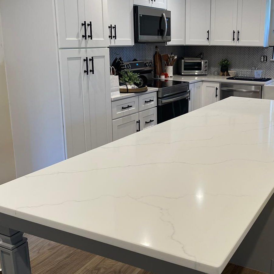 A kitchen with white cabinets and a large white counter top.