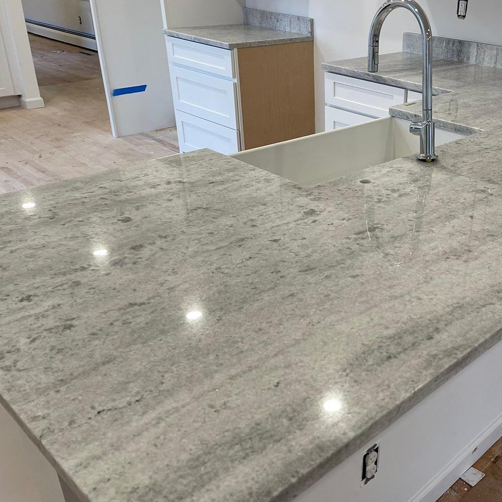A kitchen with a granite counter top and a sink.