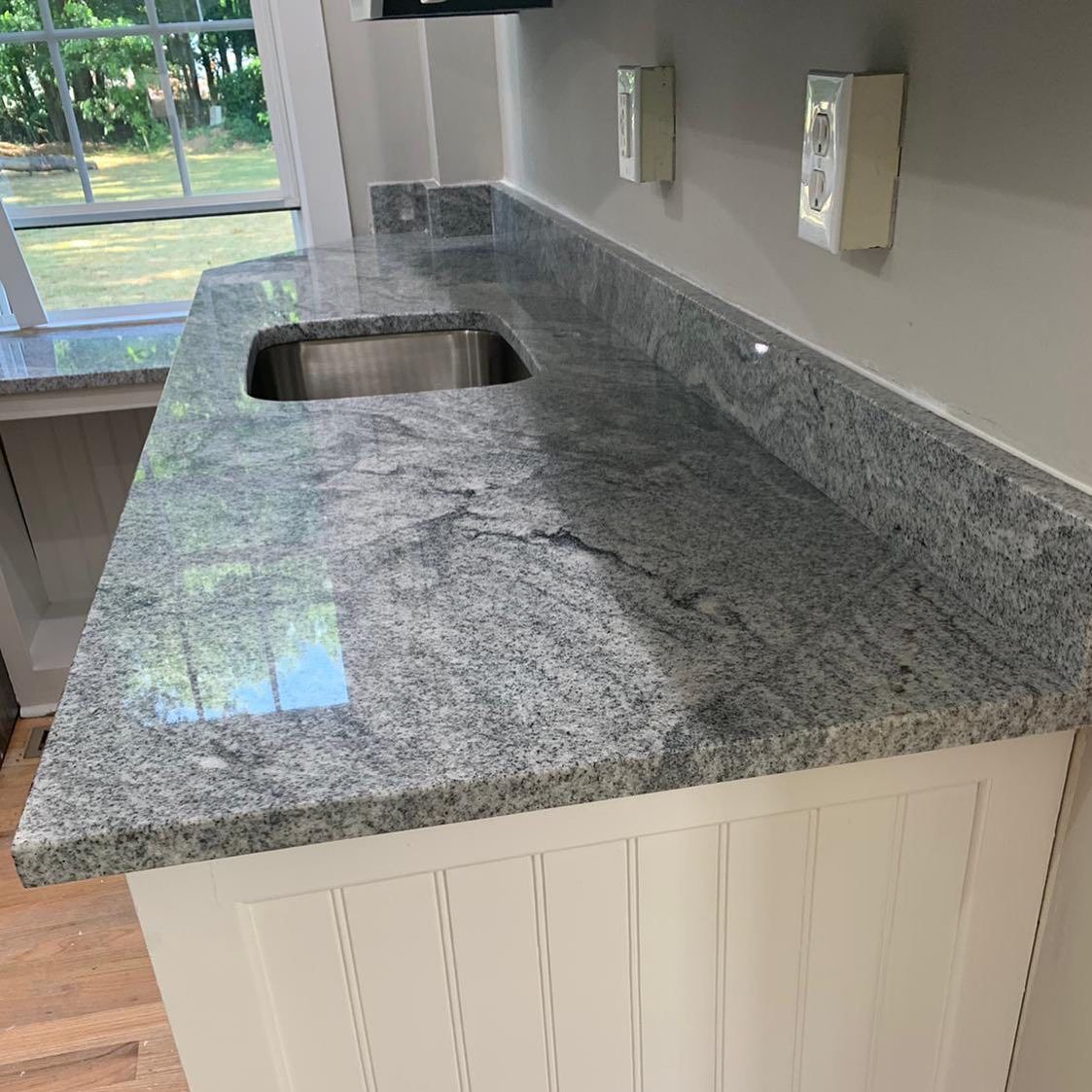 A kitchen with a granite counter top and a sink.
