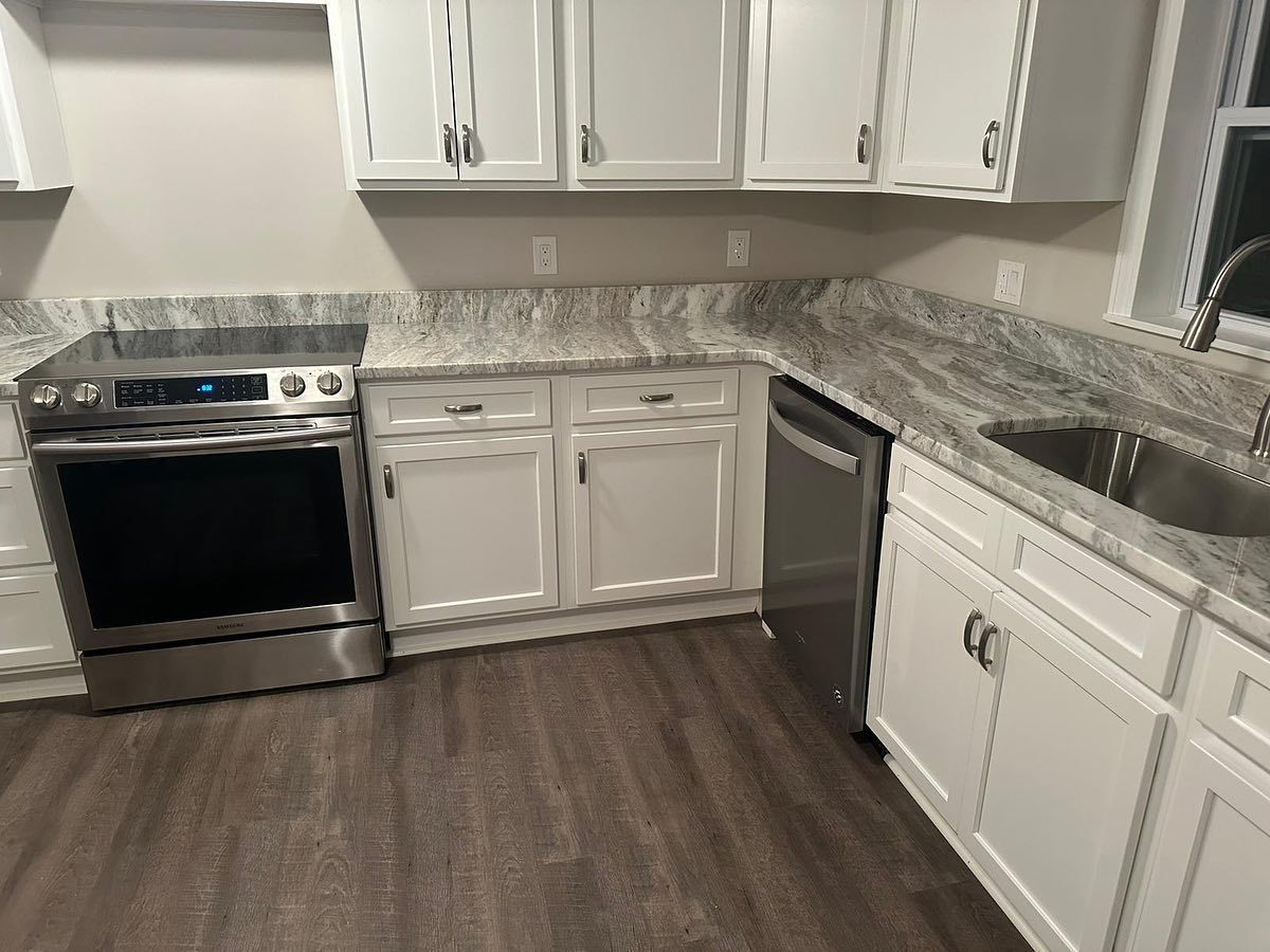 A kitchen with white cabinets and stainless steel appliances