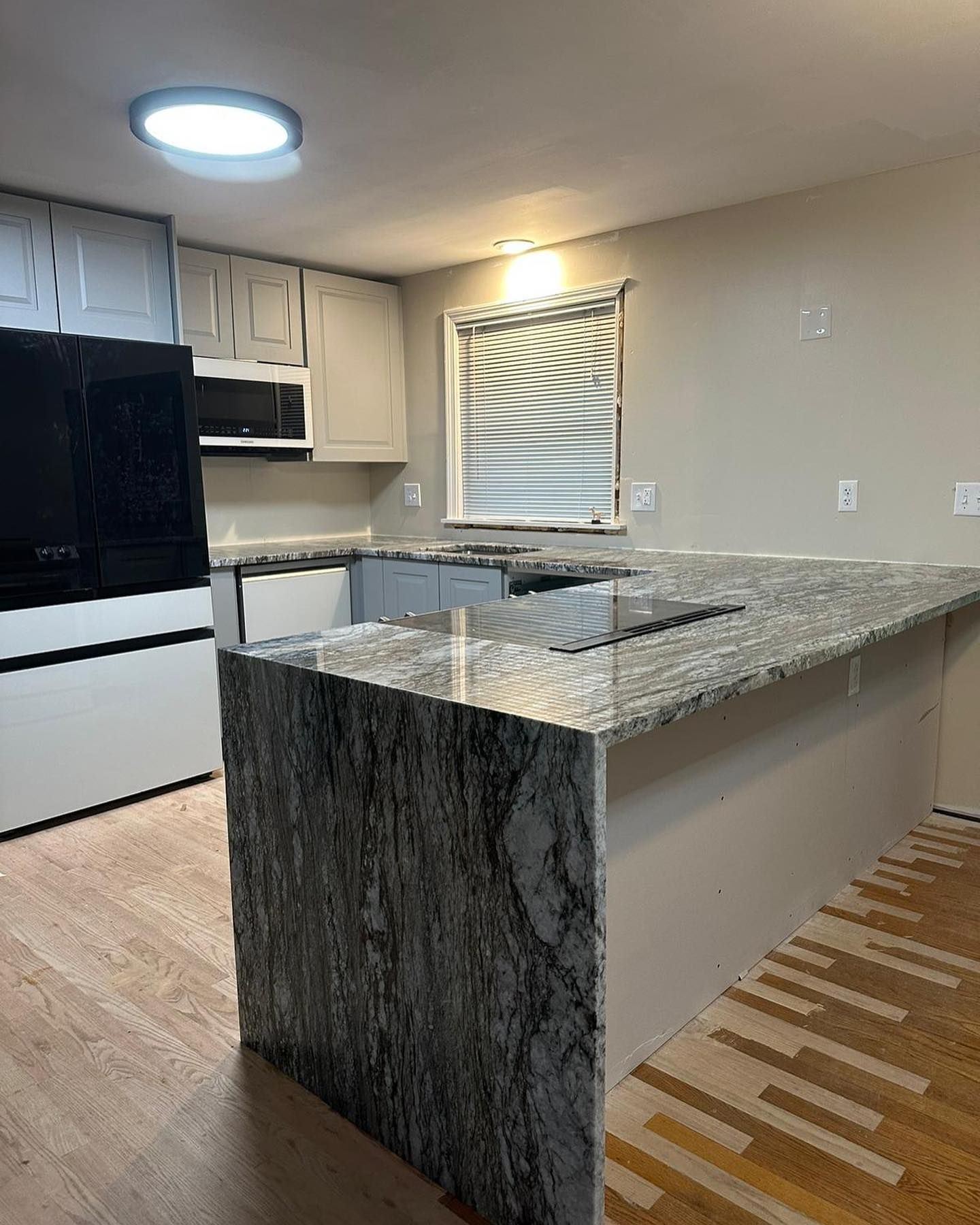 A kitchen with a large island and a window.