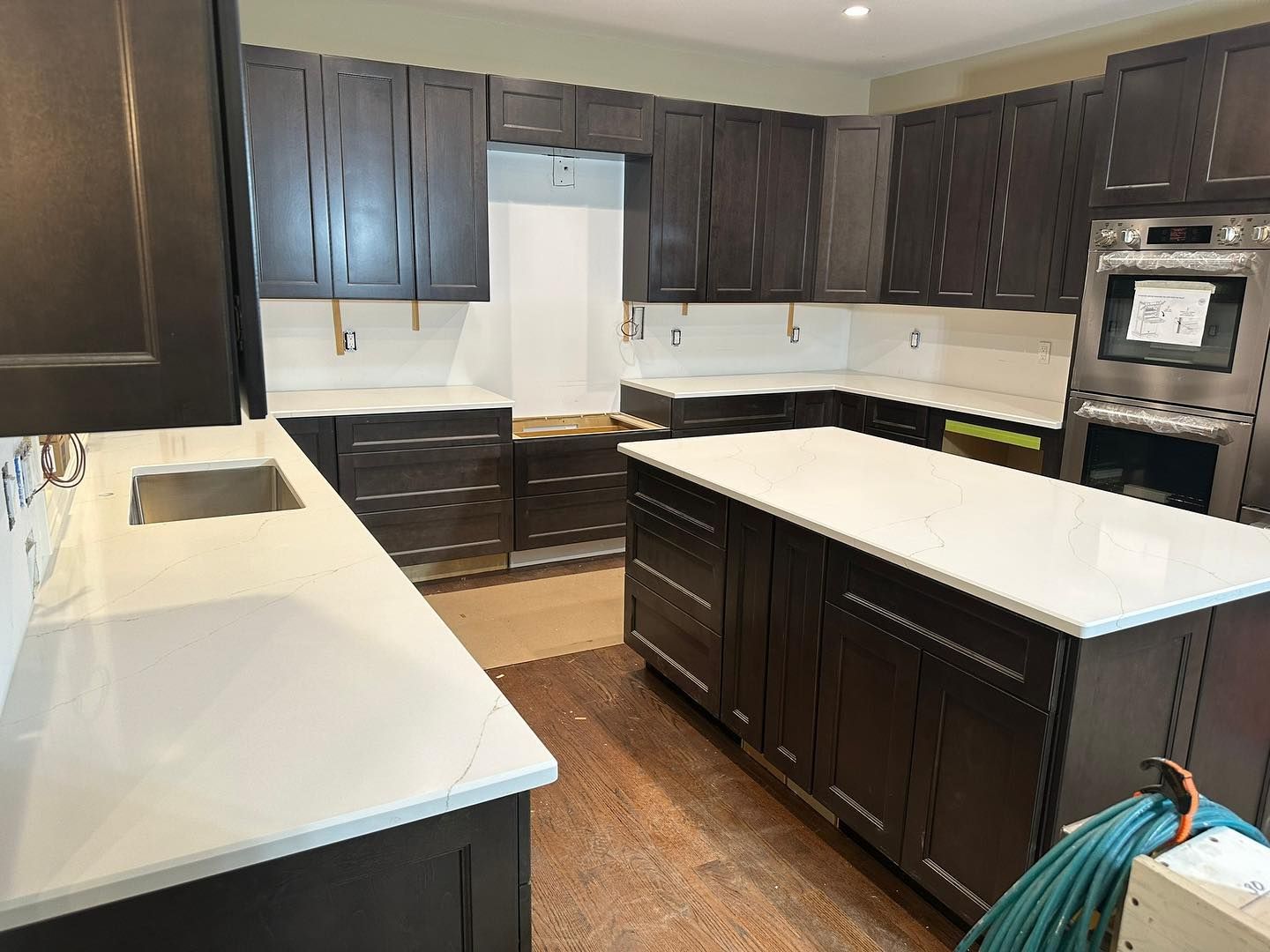 A kitchen with black cabinets and white counter tops is being remodeled.