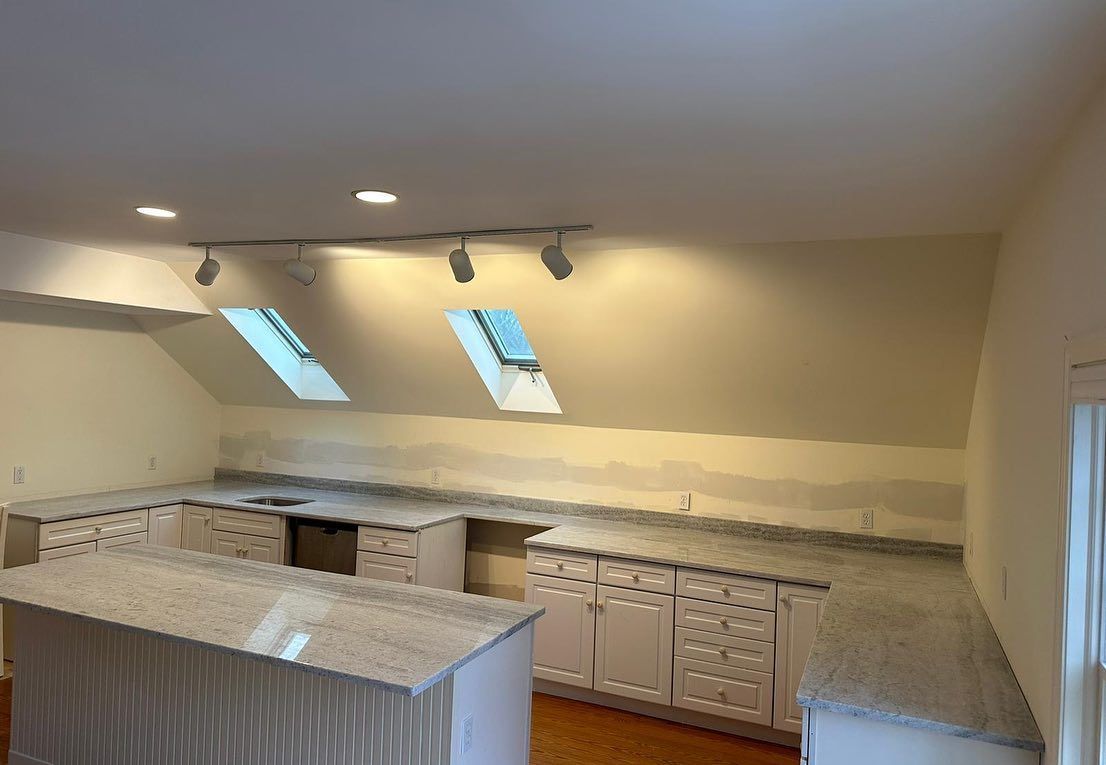 A kitchen with white cabinets and granite counter tops is being remodeled.