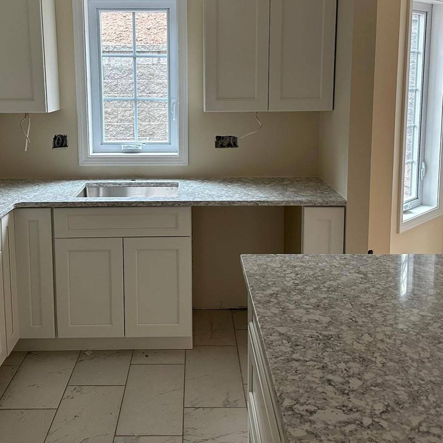 A kitchen with granite counter tops and white cabinets