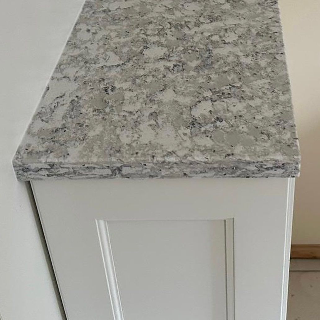 A white cabinet with a granite counter top.