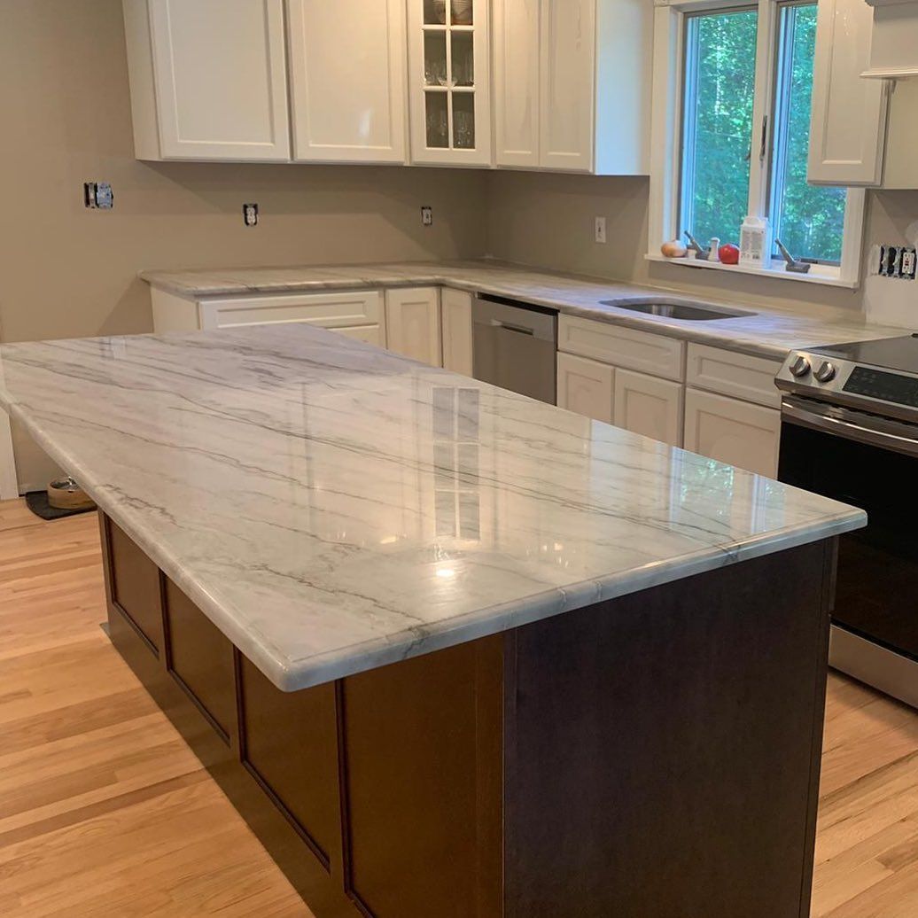 A kitchen with a large island and a marble counter top