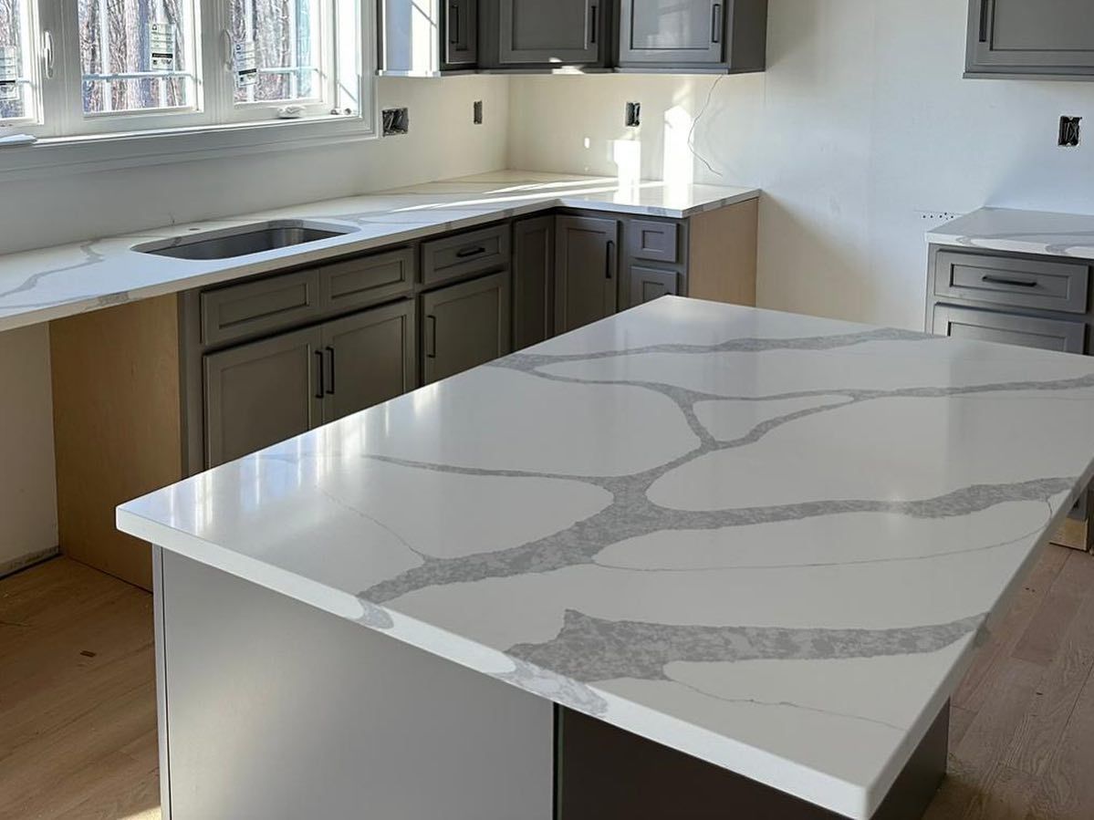 A kitchen with a large white counter top and a sink.