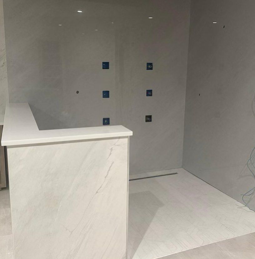 A bathroom with white tiles and blue squares on the wall.