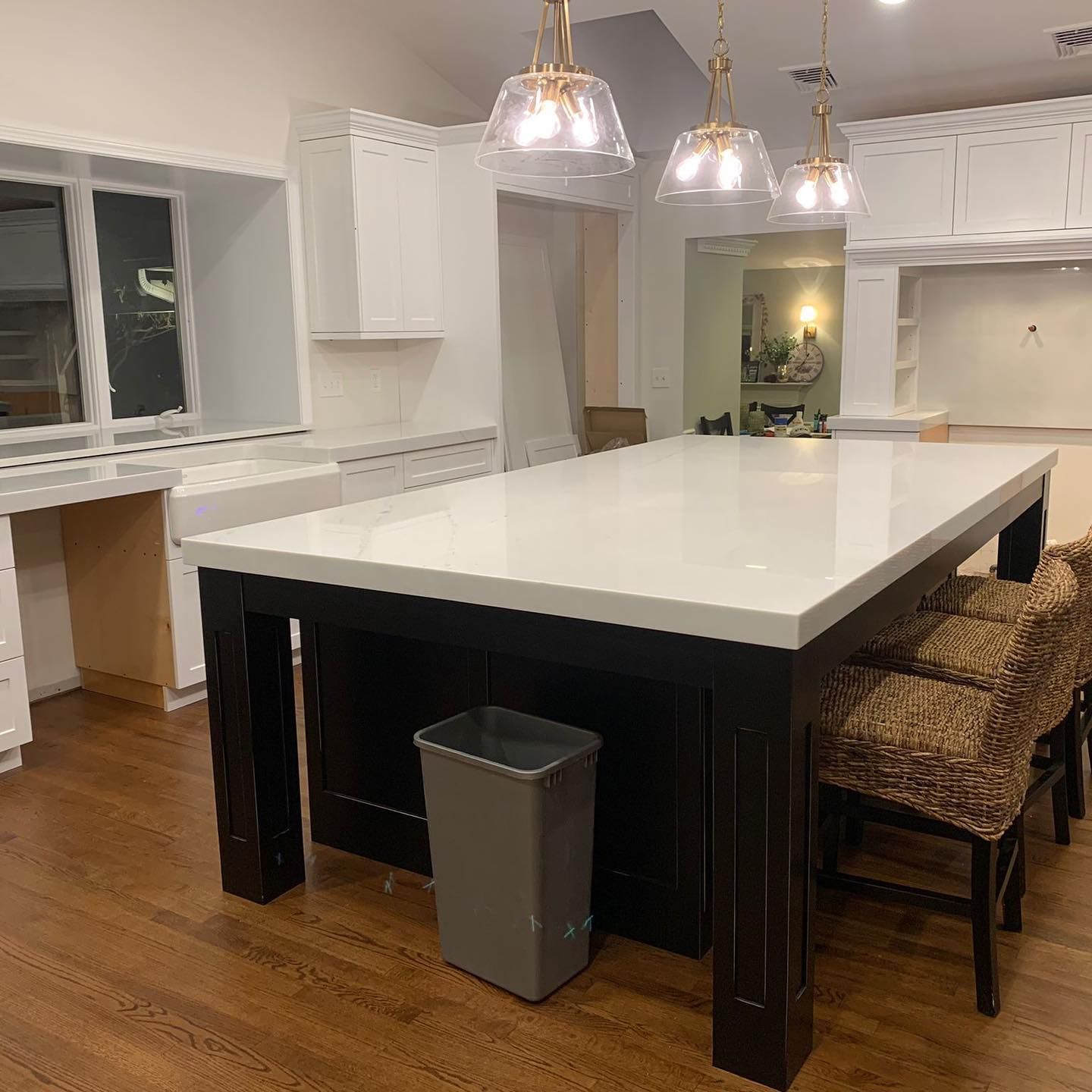 A kitchen with a large table and chairs and a trash can.