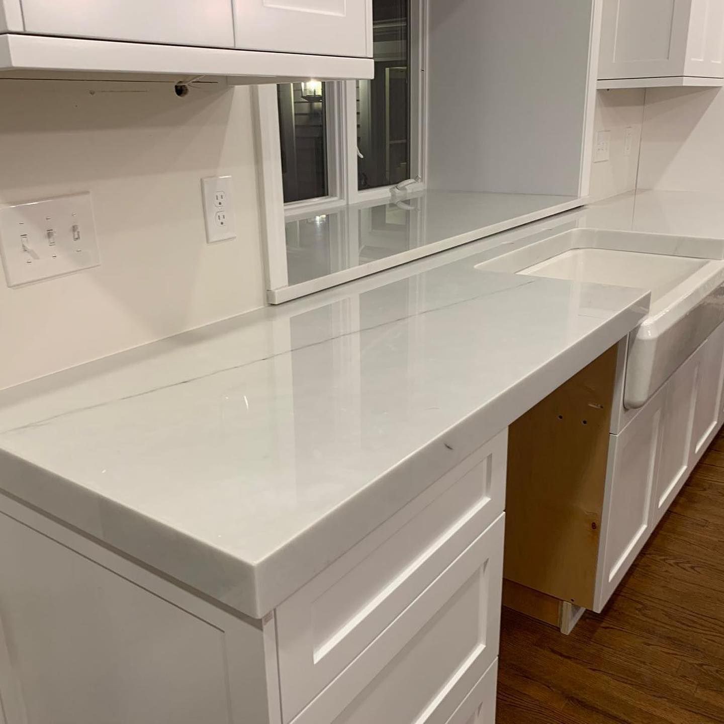 A kitchen with white cabinets and a white counter top.