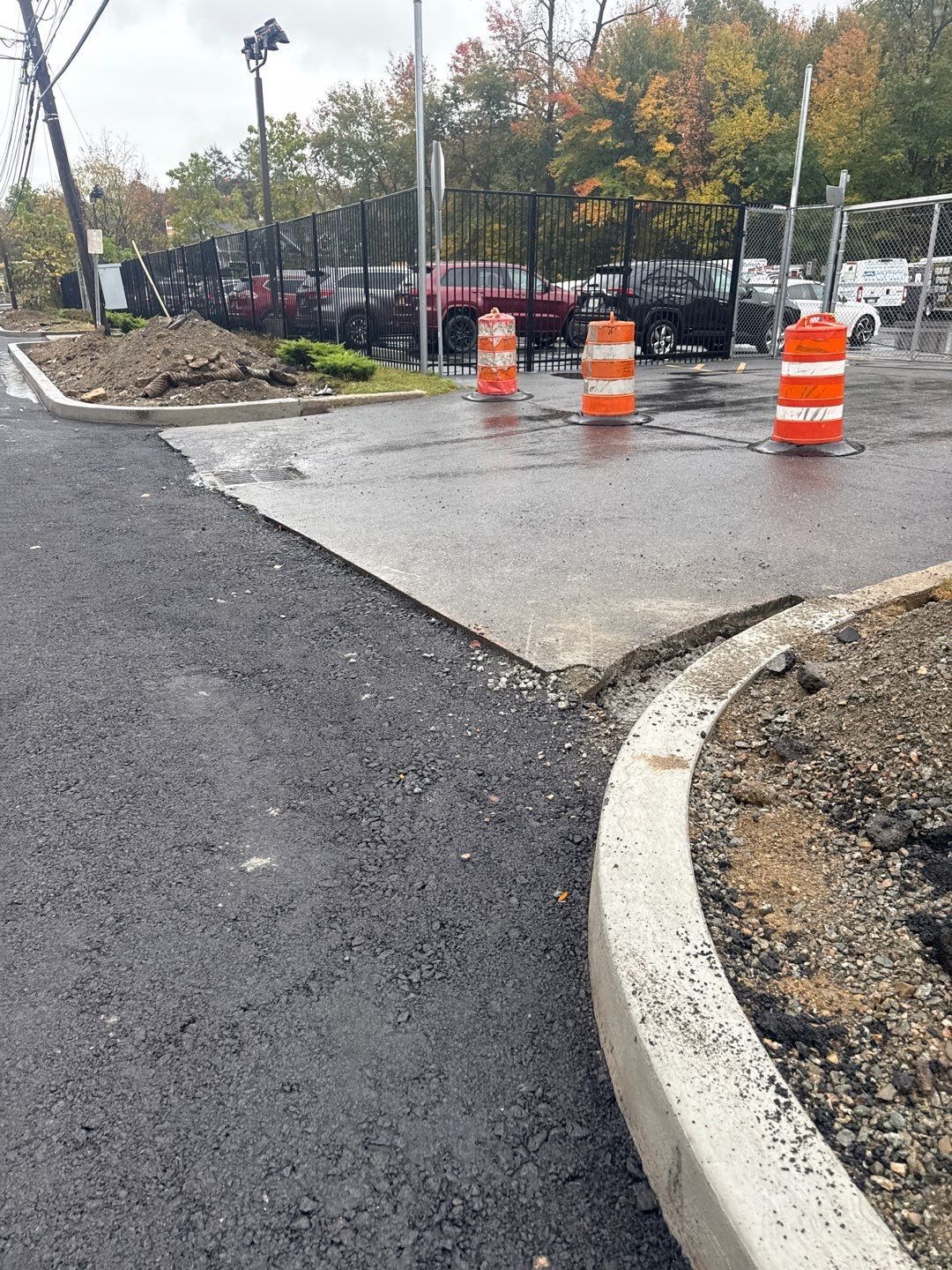 New asphalt road construction with orange traffic cones.