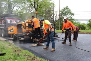 A group of construction workers are working on a road.
