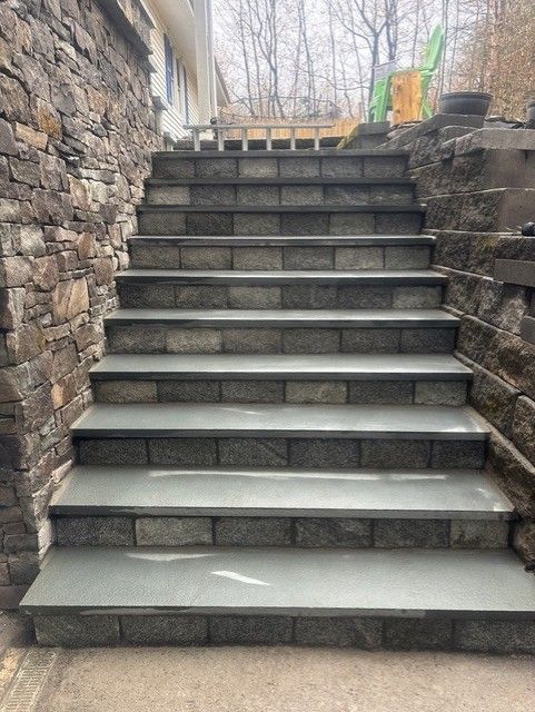 A set of stairs leading up to a stone wall.