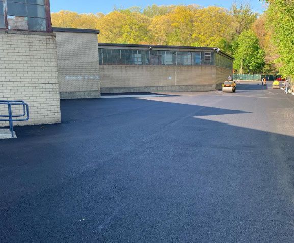 A parking lot with a brick building in the background.