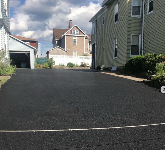 A driveway leading to a house with a white x in the middle