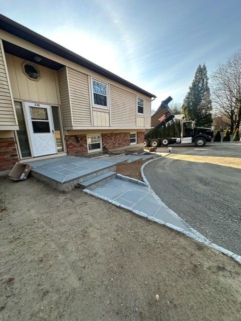 A house with a ramp in front of it and a truck parked in front of it.