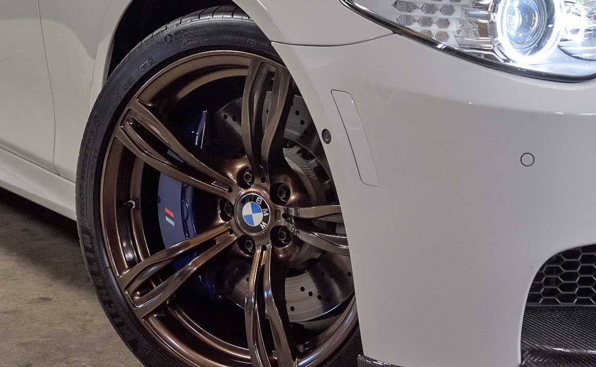 A close up of a white bmw with brown wheels