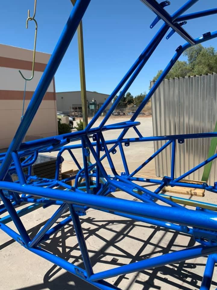 A blue metal structure is sitting in front of a building