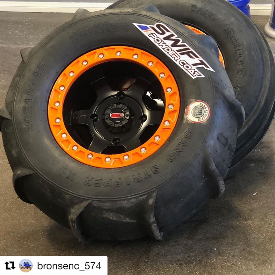 A pair of swift powder coat tires with orange rims