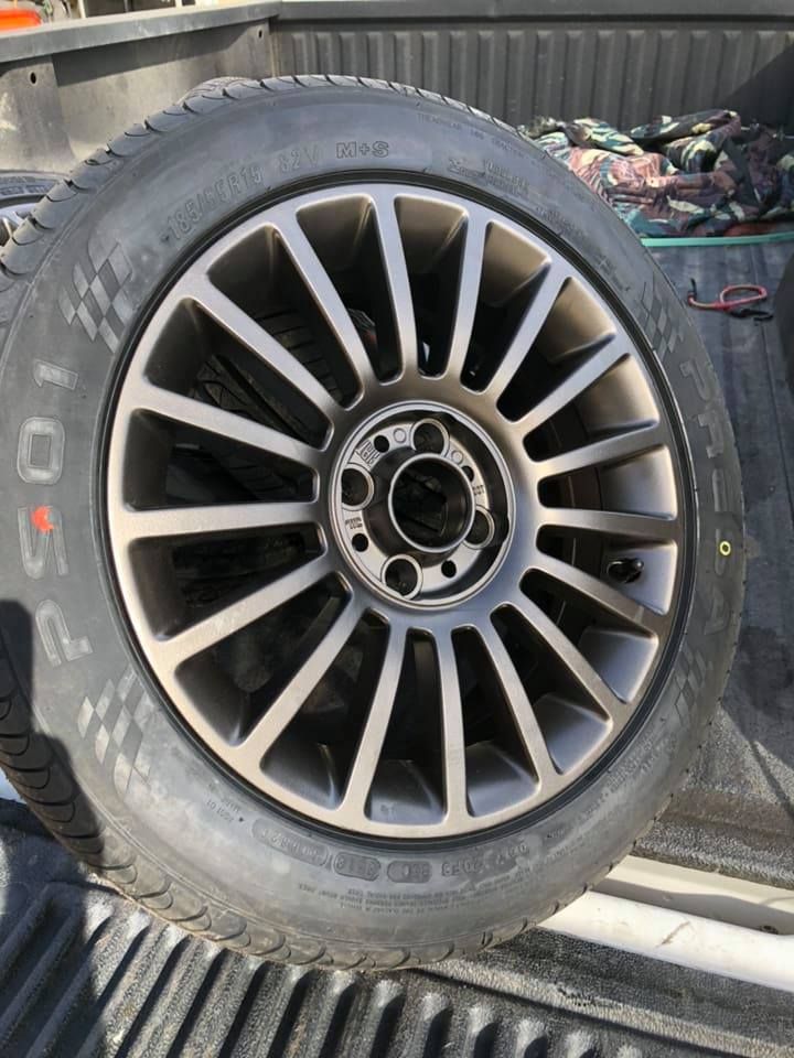 A tire is sitting on the back of a truck.