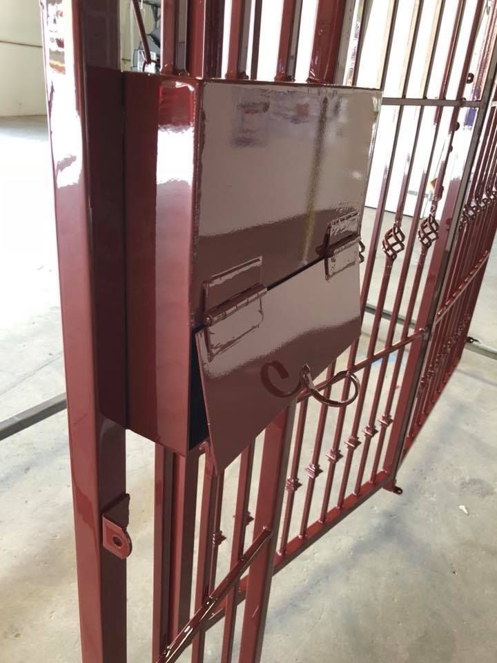 A red gate with a mailbox attached to it