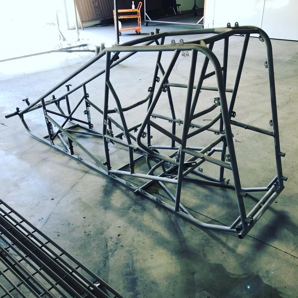 A metal frame is sitting on the floor in a garage