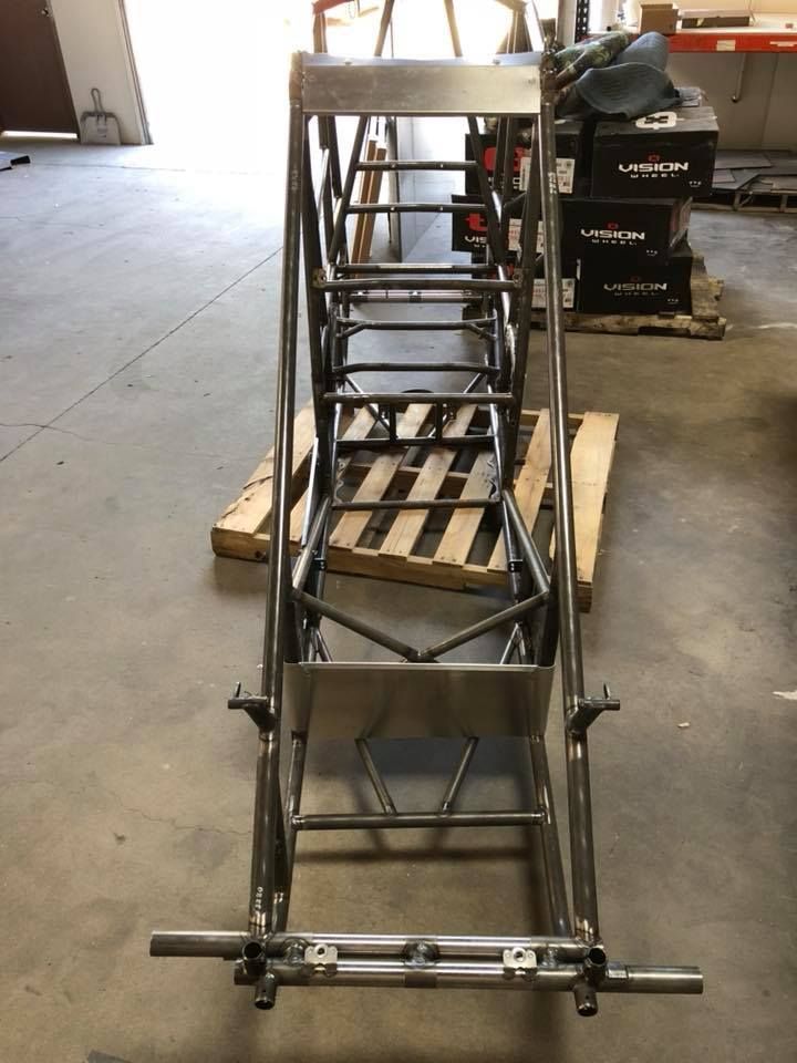 A metal frame is sitting on a wooden pallet in a garage