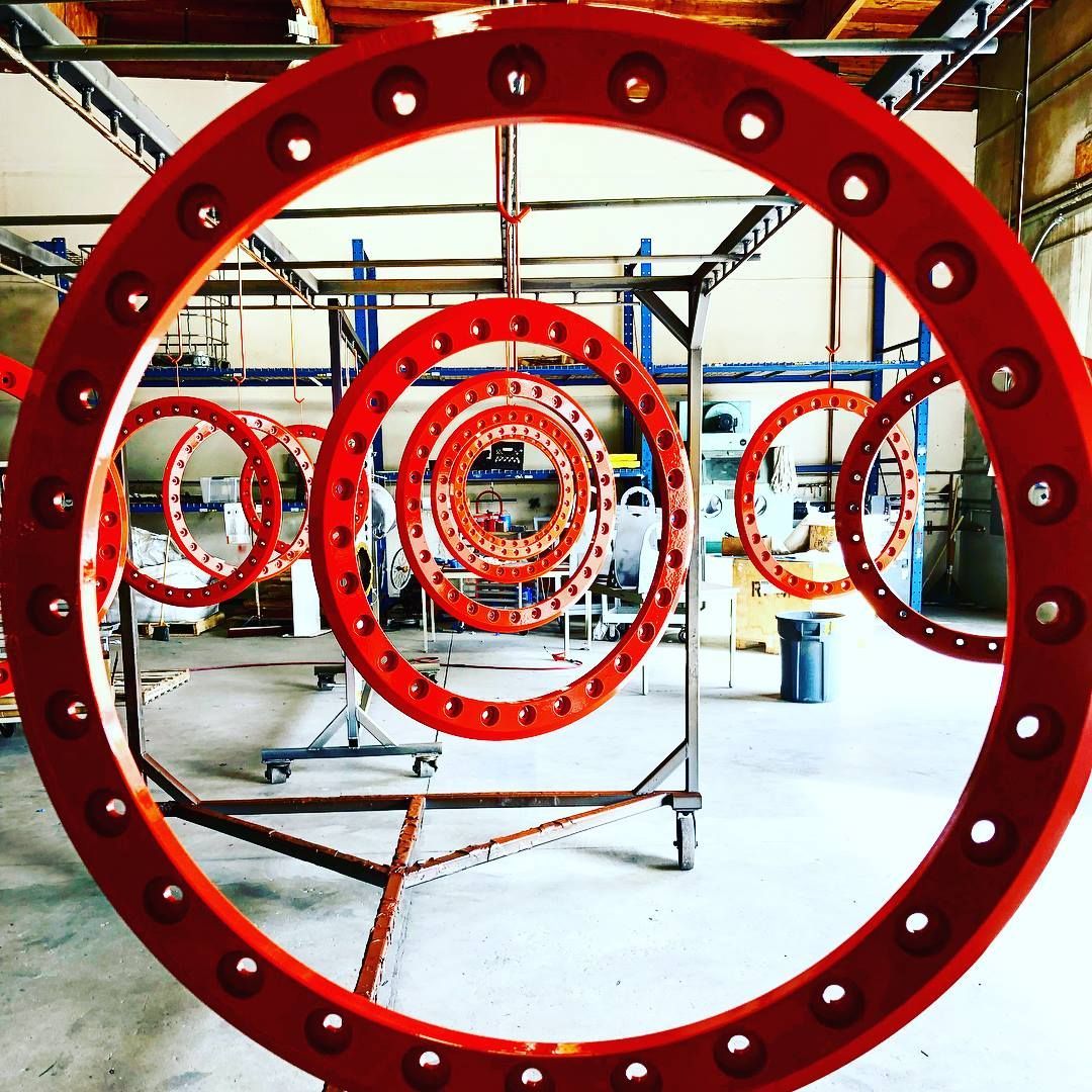 A large red circle with holes in it in a warehouse