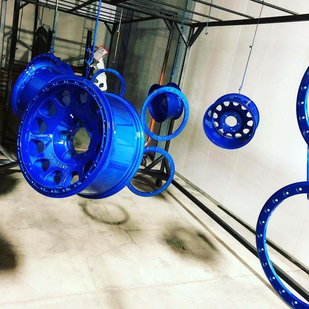 A bunch of blue wheels are hanging from the ceiling