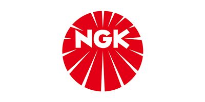 NGK logo: white letters on a red circular sunburst emblem