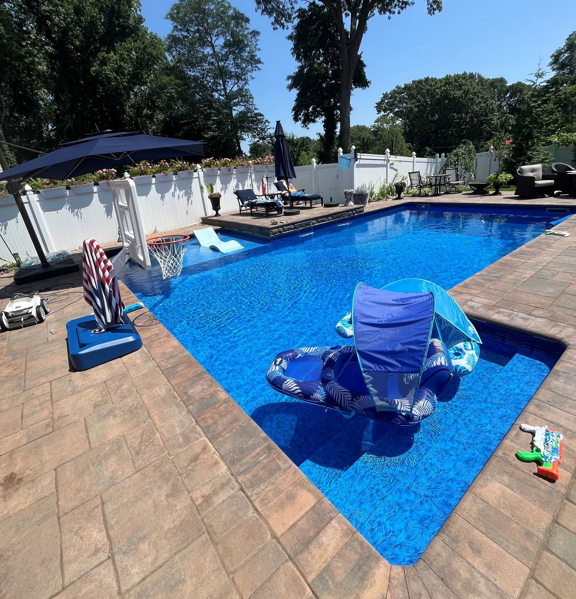 A large swimming pool with chairs and umbrellas around it