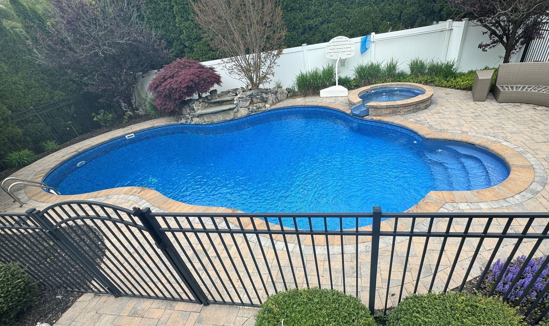 A large swimming pool surrounded by a fence in a backyard.