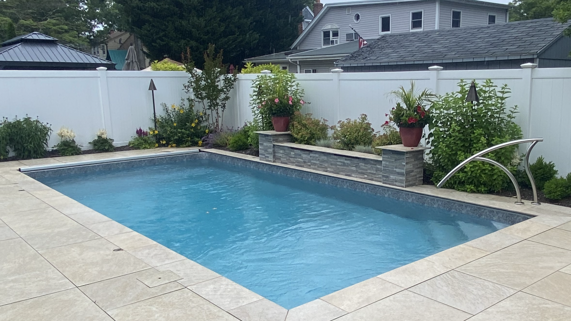 A large swimming pool with a white fence surrounding it