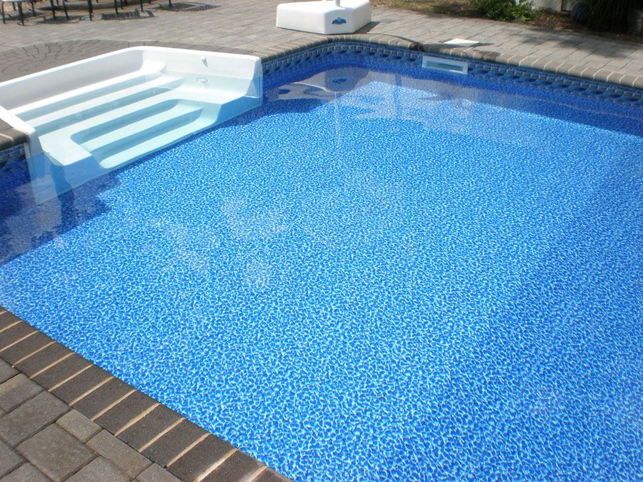 A swimming pool with blue tiles and white steps