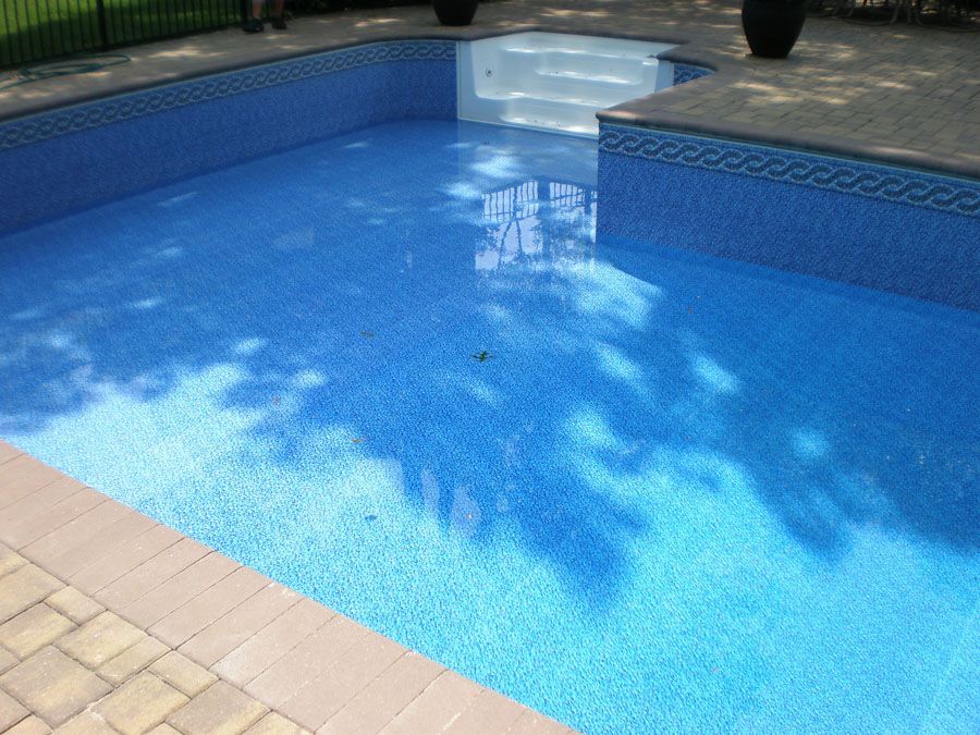 A large swimming pool with blue tiles and stairs