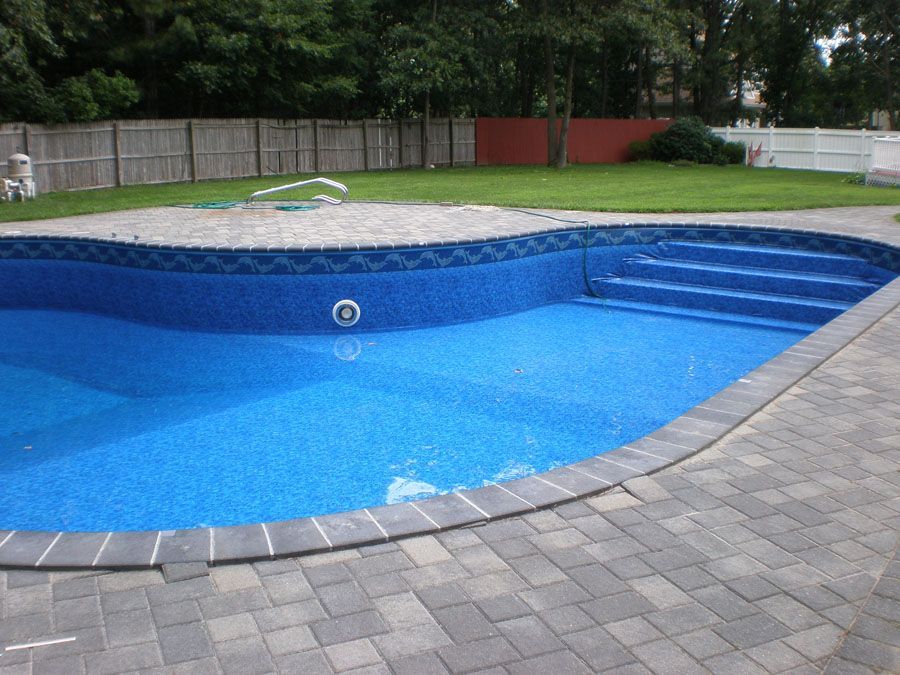 A large blue swimming pool with steps leading to it