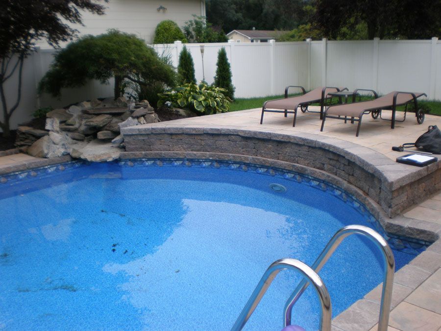 A swimming pool with a white fence in the background