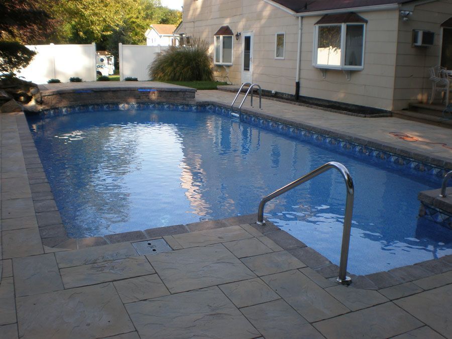 A large swimming pool in front of a house