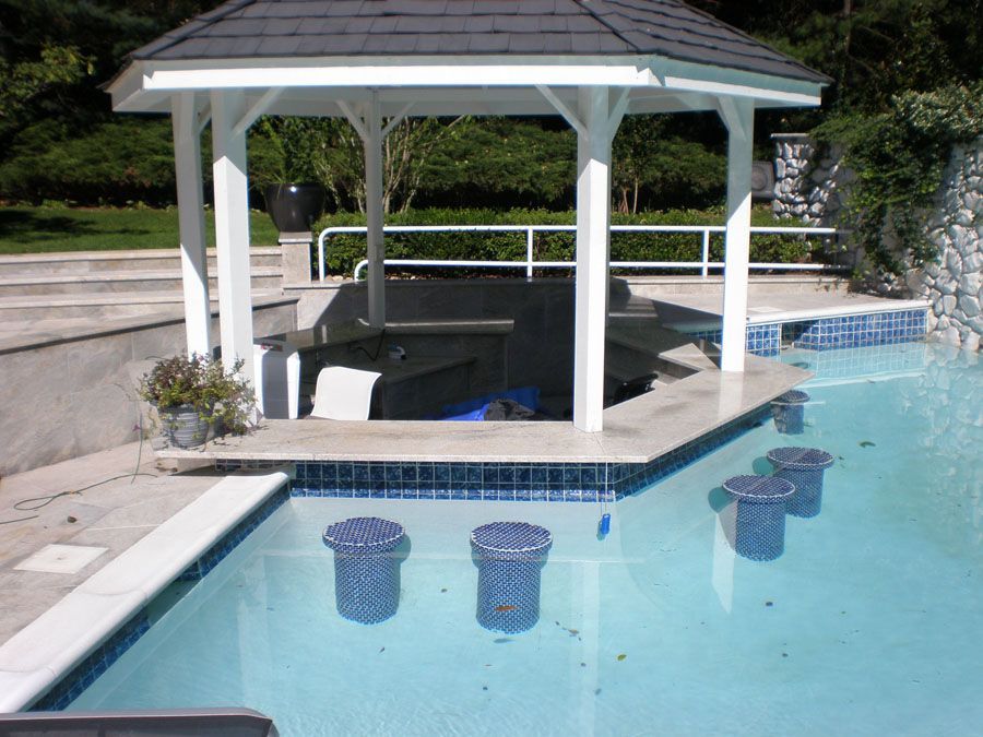 A swimming pool with a gazebo in the middle of it