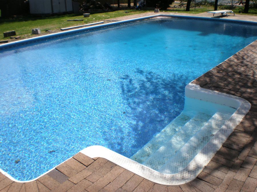 A large swimming pool with blue water and white steps